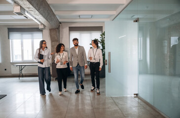 In the hall. Four office workers are together, employees at work