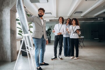 Fototapeta premium Explaining the problem with a project. Four office workers are together, employees at work