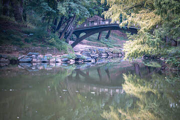 Close up view of an ancient building in Beijing, China, at the Summer Palace. Details showcase a bridge and water reflection. A peaceful scene.