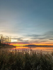 A beautiful sunrise over a quiet lake in Finland. A colorful, quiet Finnish morning. Vertical photo