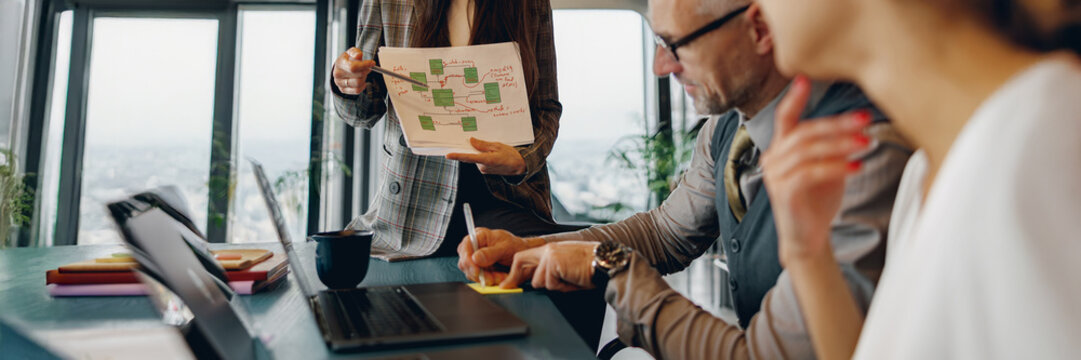A dedicated team engages in strategic talks while reviewing an innovative presentation in a creative office - Powered by Adobe