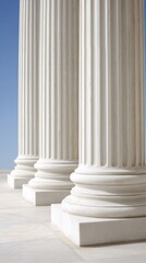 Tall classical columns stand majestically, showcasing detailed grooves and sturdy bases. Their presence evokes a sense of history and grandeur against a bright, serene sky