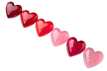 A diagonal line of glossy heart shaped candies in various shades of pink and red against a black background