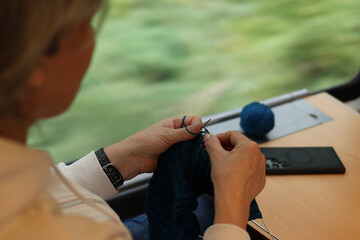 Women's hands knit by the train window