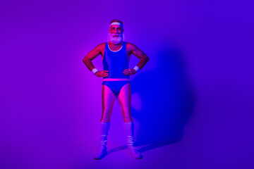 Senior bearded man in retro athletic costume stands confidently under neon purple and blue lights for sporty lifestyle fashion and advertising