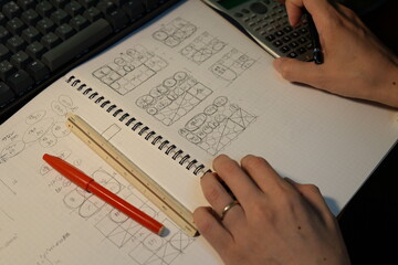 Obraz premium 夜にプランを検討する建築士の手元 The hands of an architect reviewing plans at night