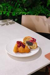 Freshly baked pastry with raspberry filling on a white plate in a cozy setting