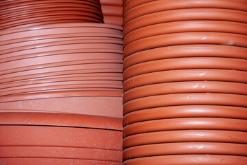 Zwei Stapel mit Blumentopf Untersetzer in braunroter Farbe aus Kunststoff