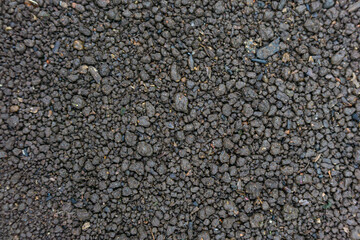 Close-up View of Wet Garden Soil Mixed with Small Gravel, Showing Natural Texture and Earthy Surface Detail. Suitable for Agriculture, Gardening, and Natural Texture Backgrounds.