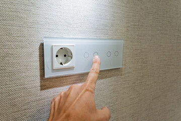 touch control lights, gesturebased lighting management in contemporary apartment ambiance, closing look at fingertip touchsensitive panel with led illumination in evening setting