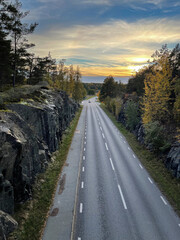 Obraz premium The road between the rocks stretches into the distance towards the setting sun