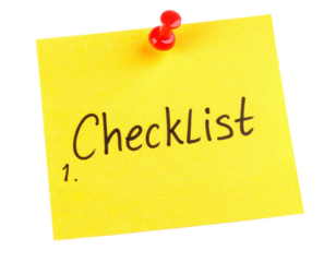 A bright yellow sticky note with the word "Checklist" written in bold black letters.