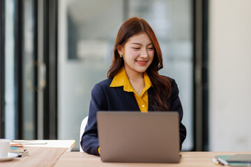 Portrait of young asian business woman using laptop computer and working at office, planning...