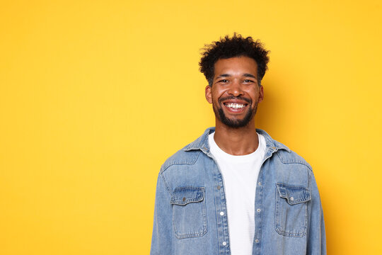 Portrait of happy man on orange background, space for text - Powered by Adobe