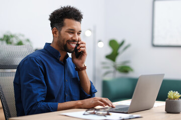 Man working on laptop at table in office