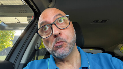 The angry man reacts aggressively while driving his car displaying visible stress and irritation during everyday urban traffic.