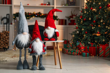 Obraz premium Funny Christmas gnomes in festive decorated room, space for text