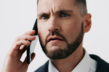 A focused business professional on a mobile call, portrait against a solid colored backdrop,...