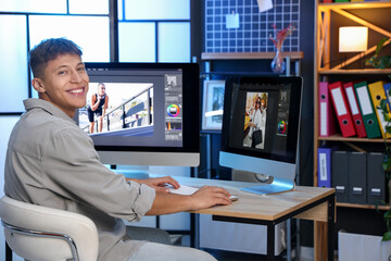 Professional retoucher editing photo on computer at table in office