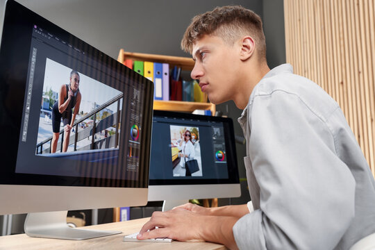 Professional retoucher editing photo on computer at table in office, low angle view - Powered by Adobe