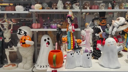 Colorful Halloween decorations including ghosts, pumpkins, and skeletons displayed on shelves in a...
