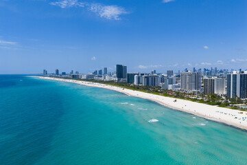 Miami beach with turquoise waters. Aerial view of sandy coastline and waves. Tropical Miami Beach scene with sandy beach. Oceanfront of South Miami. Panoramic of Miami Beach.