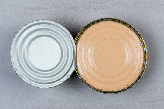 Open canned food with pate on a gray background top view