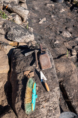 A vertical composition of archaeological tools on a large stone The Archaeologist's Still Life