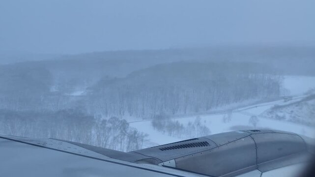 plane landing in heavy snow winter day at sapporo new chitose airport in hokkaido airplane wing view video