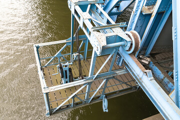 A metal maintenance platform under a bridge, designed for inspection and repair work