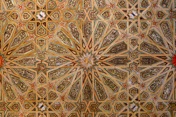 Detail of an ornate wooden ceiling at the Real Alcázar of Seville, decorated with intricate...