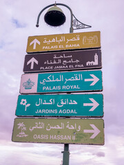 Iconic Stacked Directional Sign in Marrakech, Morocco, Guiding Tourists to Bahia Palace, Jemaa el-Fna Square, Royal Palace, and Agdal Gardens