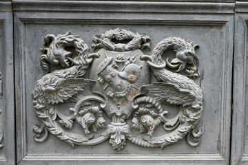 Stone relief of a heraldic coat of arms flanked by two basilisks on Seville Town Hall