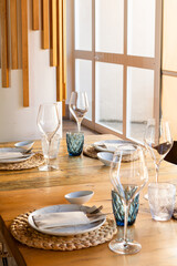 Set table with plates, glasses and cutlery in luxury modern wooden restaurant