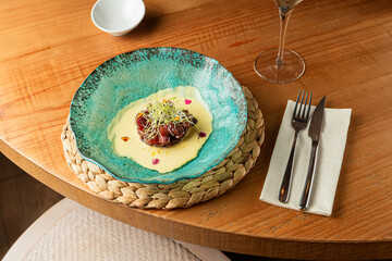 Red tuna tartare in luxury restaurant interior with warm wooden design