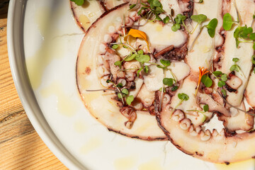Designer octopus dish on sunny table in luxury restaurant