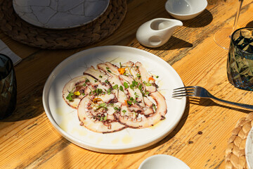 Designer octopus dish on sunny table in luxury restaurant