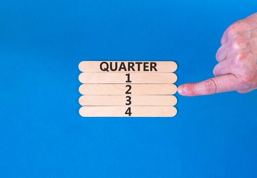 2nd second quarter 2 symbol. Concept word Quarter 2 on beautiful wooden sticks. Beautiful blue background. Businessman's hand. Business, happy 2nd second quarter 2 Q2 concept. Copy space.