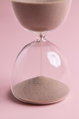 Close up of the flowing sand inside hourglass. Concepts of time still life.