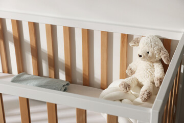 Crib with toy and pillow in baby's room, closeup