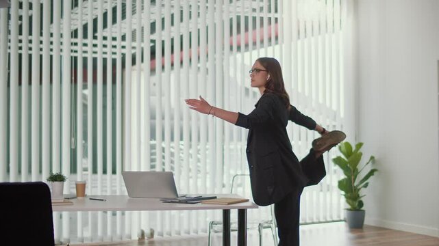 Positive Workplace and Healthy Culture. Office Manager Performs Balancing Spine and Leg Stretch Beside Desk to Build Strength Improve Flexibility Enhance Focus and Support Energized Office Environment