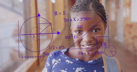 Smiling student wearing denim backpack walking in brick hallway, displaying purple math diagrams