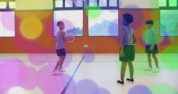 Boy in sleeveless top, shorts passing basketball in gym with court lines and windows, copy space - Powered by Adobe