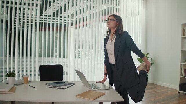 Mindfulness at Work and Employee Wellbeing. Office Manager Performs Standing Quadriceps and Lumbar Spine Stretch at Desk to Improve Posture, Reduce Tension, Boost Focus and Support Healthy Workplace