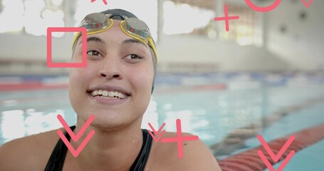 Smiling swimmer with yellow cap, goggles wading in pool with lane dividers, red graphics overlaying