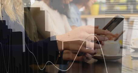 Holding smartphone between hands over wooden cafe table with cup, showing colleagues analyzing data