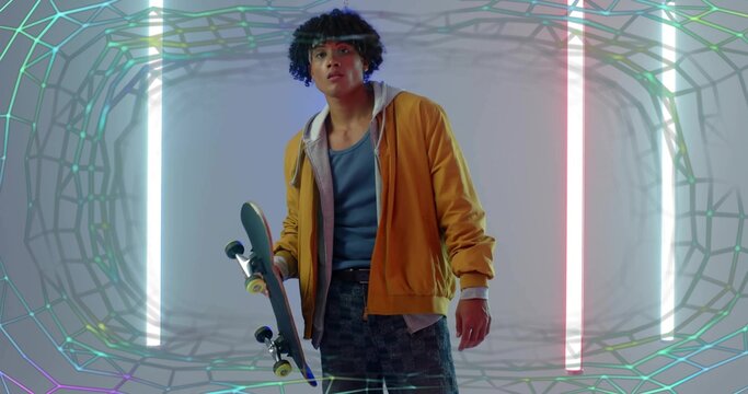 Holding skateboard, skateboarder wearing mustard jacket in studio, neon tubes and wireframe overlay - Powered by Adobe