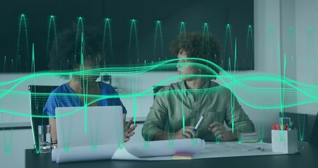 Collaborating coworkers in shirts pointing at laptop, reviewing plans in office with green waveform
