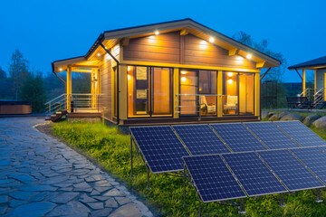 Obraz premium Modern eco house with solar panels at evening, renewable energy solutions and sustainable residential power supply.