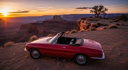 Classic red convertible car parked on cliff edge overlooking stunning sunset over majestic canyon scenery